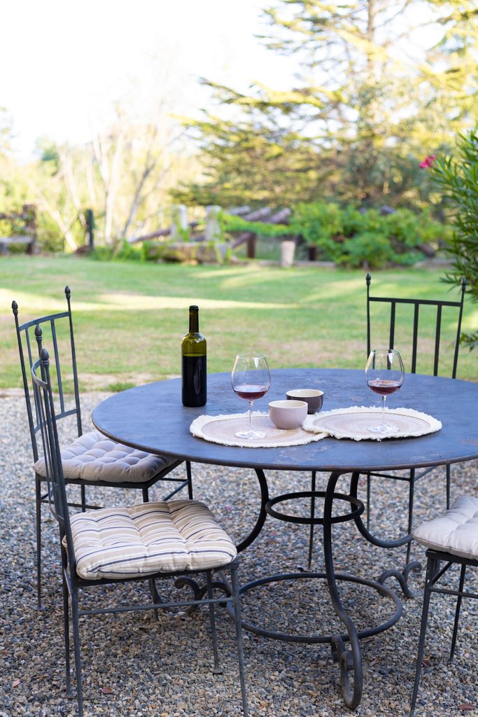 Tavolo in ferro battuto in giardino con vino e calici