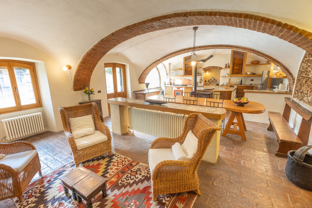 Soggiorno con cucina rustica e finestra ad arco